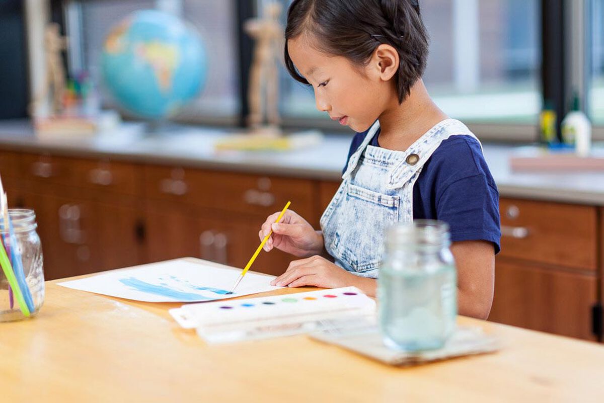 Right view of girl painting with Watercolors Classpack, 24 Count 8 Colors.